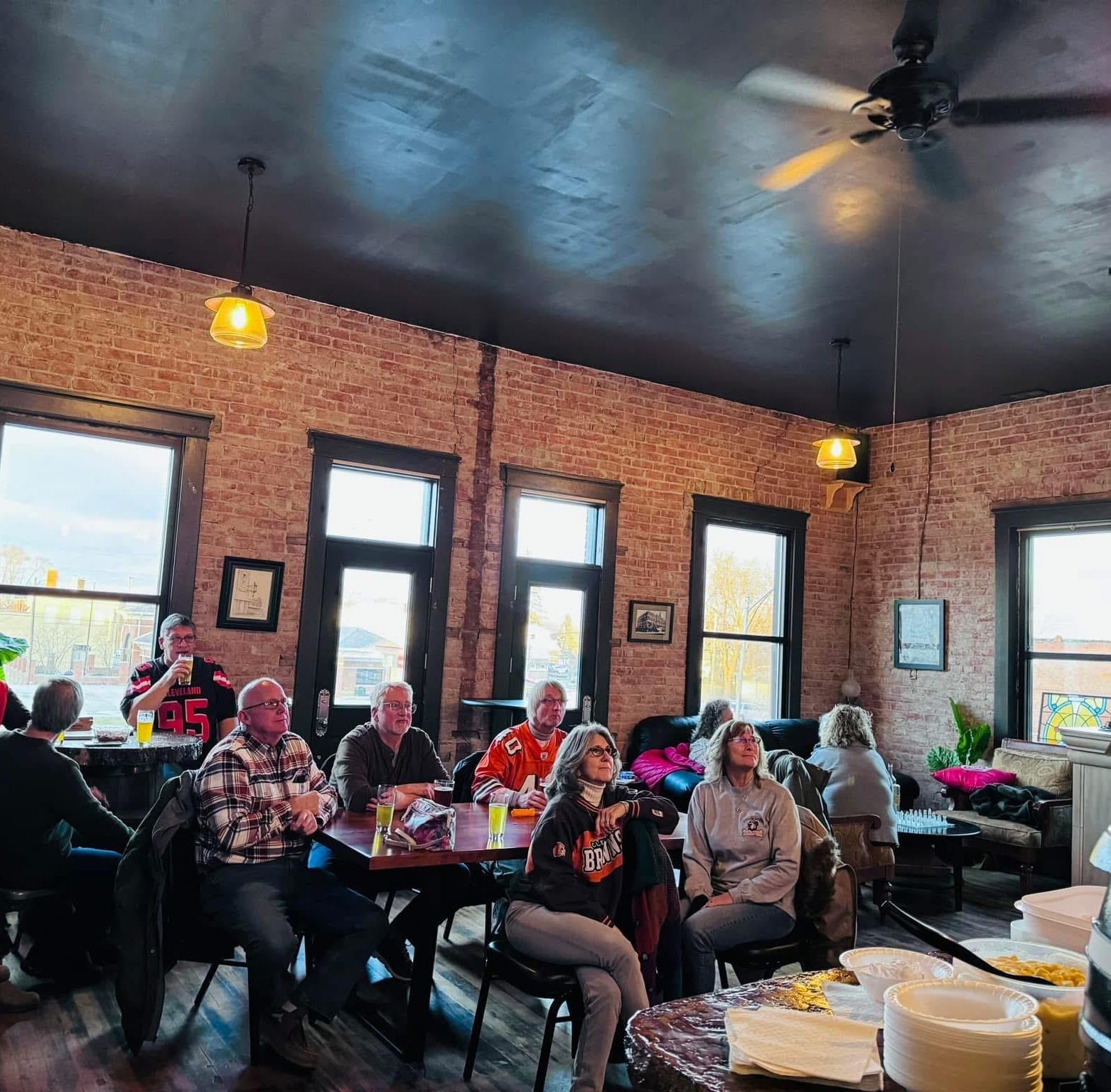 Guests dining under exposed brick walls inside the UrbanWoody taproom